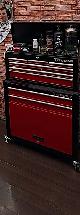 Cajonera roja con productos junto a un espejo redondo