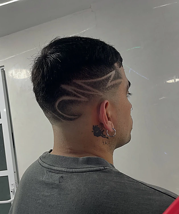 Diseño freestyle de trazos curvos rasurado en la nuca