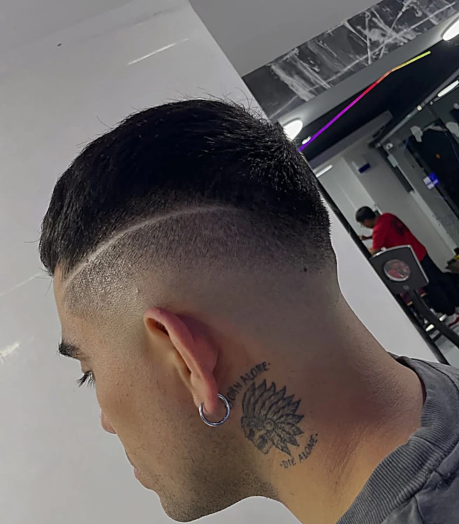 Fade alto con dos líneas de diseño rasuradas en el costado de la cabeza